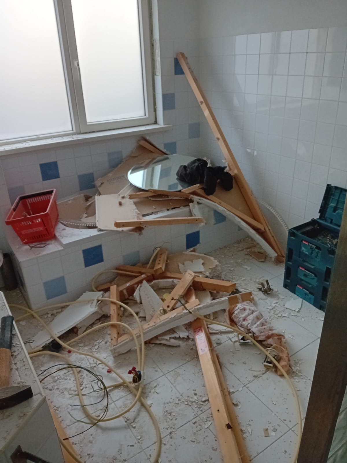 Oude badkamer tijdens de sloop, met hout en puin op de vloer