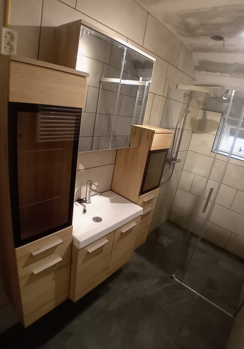 Vernieuwde badkamer met eikenhouten kasten, wastafel en glazen inloopdouche
