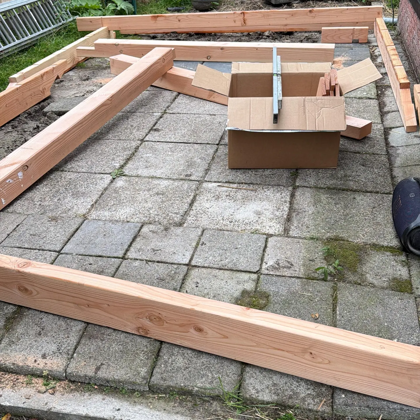 Houten balken op maat uitgelegd op de tegels van een terras