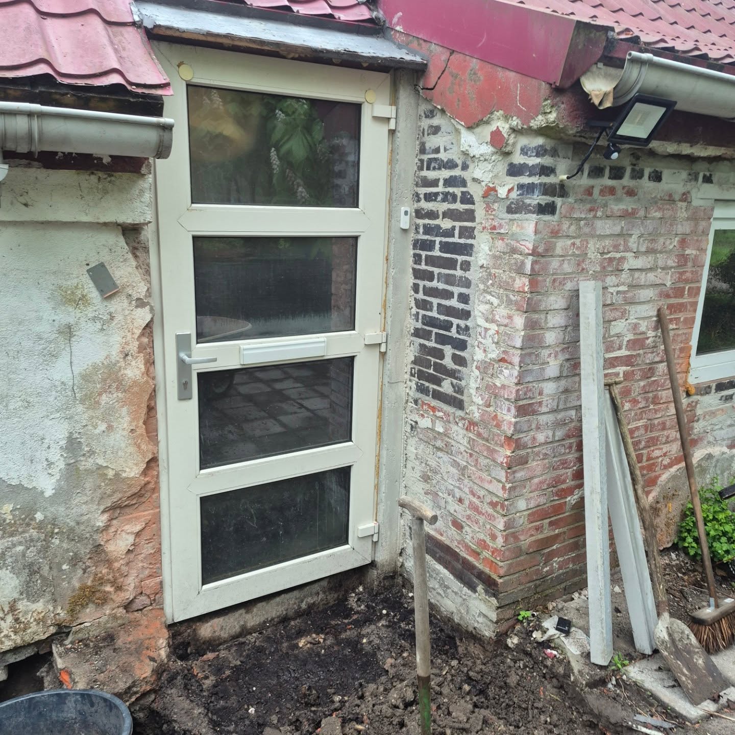 Uitbouw van een entree met nieuw kozijn en deur, nog in aanbouw